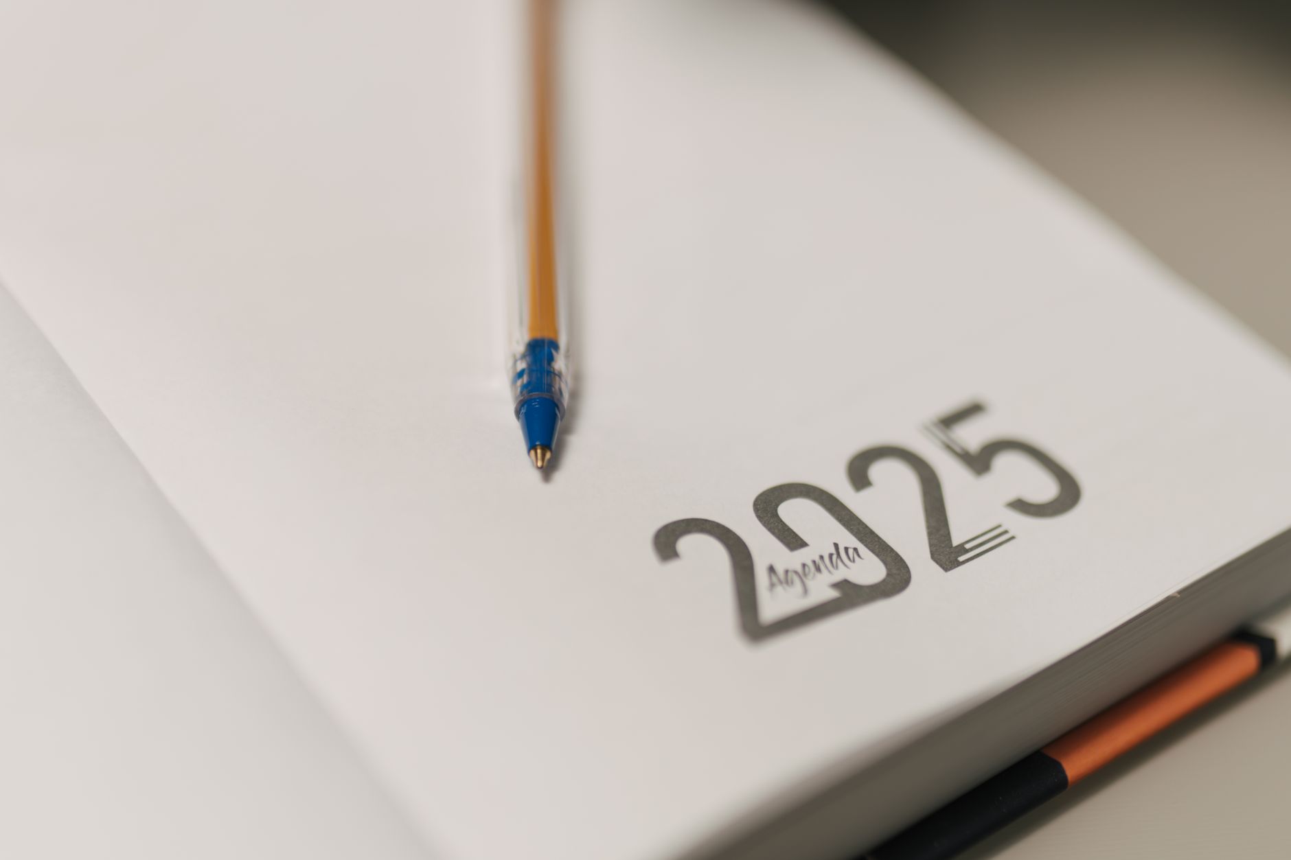 Notesbog, pen og kalender på et bord